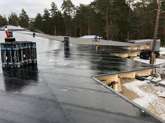 Suure eramu lamekatus ja varikatuse puitkandekonstruktsioon talvel